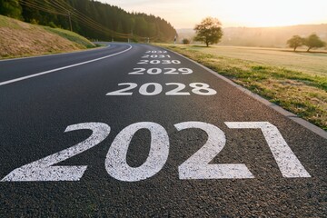Fototapeta premium 2027 Future road with painted years showing progress and planning as a time line concept for growth vision and strategy