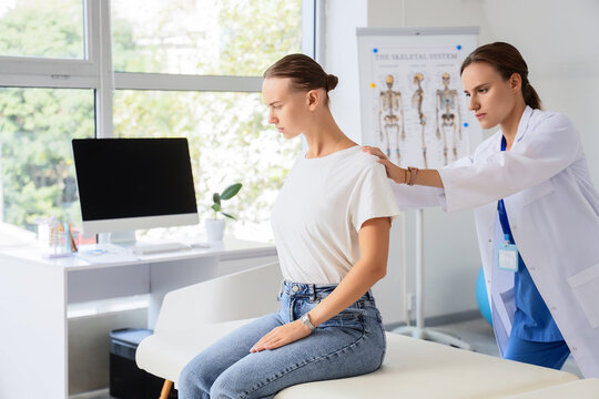 Physical therapy and posture correction, doctor examining patient shoulder pain and spinal alignment in medical clinic office for rehabilitation therapy