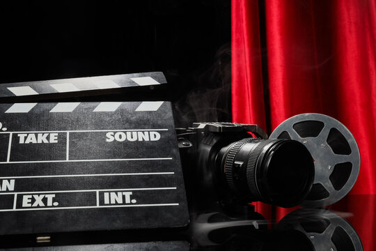 Film production and cinema industry, movie clapperboard with camera and film reel on stage with red curtains and smoke for entertainment media