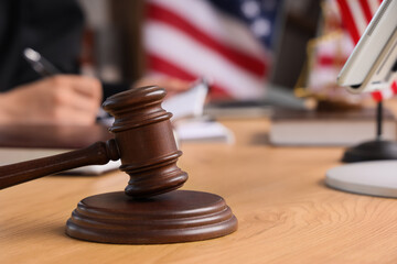 Legal justice and judicial system, wooden judge gavel on courtroom desk with American flag and...
