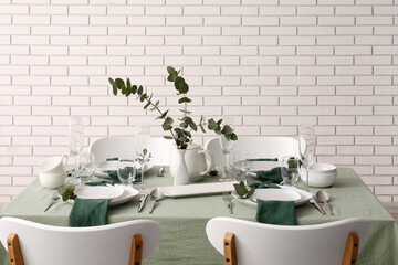 Hospitality and fine dining, elegant table setting with eucalyptus decor and green linen for restaurant service or home dinner party in modern interior © Pixel-Shot
