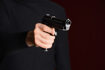 Obraz premium Gun violence and crime prevention, person holding a black handgun in a dark room for security and self defense