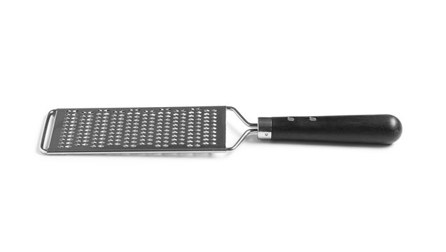 Food preparation and culinary arts, metal cheese grater with wooden handle for cooking and kitchen tasks isolated on a clean white background