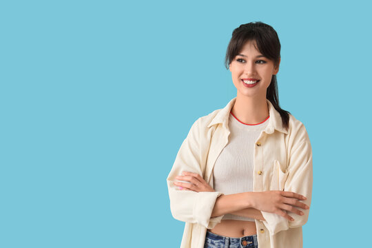Confidence and positive mindset, smiling young woman with arms crossed looking away on blue background