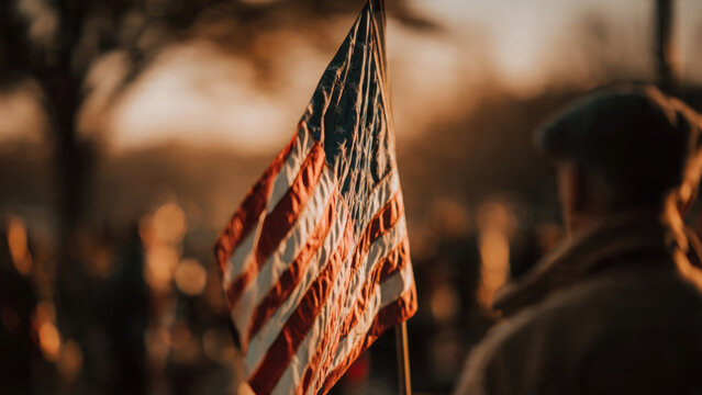 Waving American flag held by a person during a patriotic outdoor event
