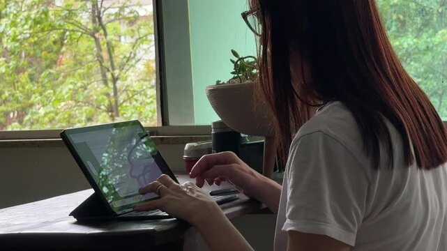 Close-up handheld, home office technology use with mature female typing on her laptop, illustrating remote flexible jobs, digital productivity and modern professional lifestyles