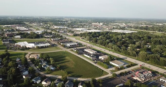 Aerial drone view of a busy street with businesses and homes in a subdivision in Rockford, Illinois.