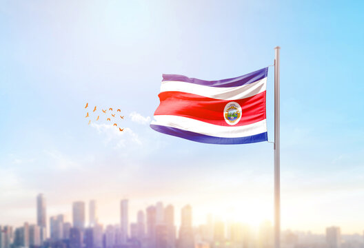 Costa Rica national flag waving with skyline and buildings.