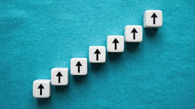 Seven white dice with upward arrows are arranged in a step-like pattern on a textured blue surface. The dice create a visual representation of progress or upward movement.