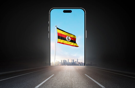 Uganda national flag on phone screen over highway to city. Uganda flag for Republic Day and Independence Day.