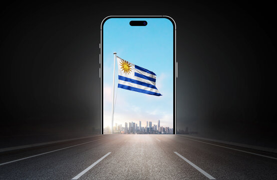Uruguay national flag on phone screen over highway to city. Uruguay flag for Republic Day and Independence Day.