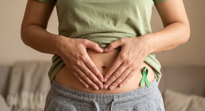Woman's hands making Heart Shape on Stomach for Celiac Disease Awareness