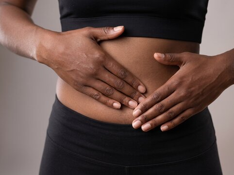 Close-up of a holding stomach in pain experiencing digestive issues or coeliac disease symptoms
