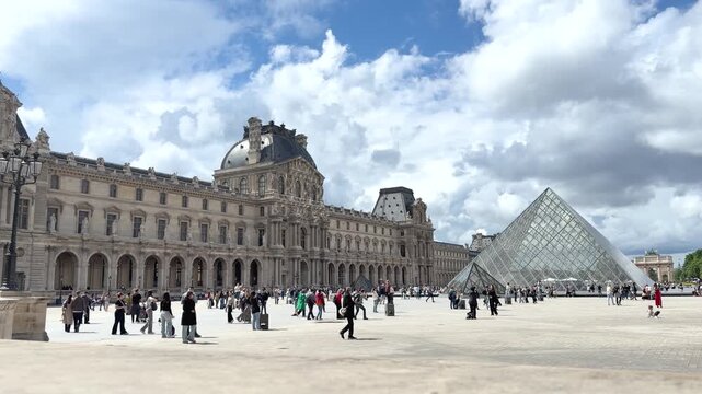 Tourists Walking in Louvre Courtyard by Glass Pyramid in Paris
