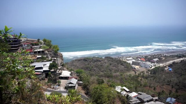 A panoramic view of Java's southern coast and the crashing waves of Parangtritis Beach, captured from the top of the Obelix cliff.