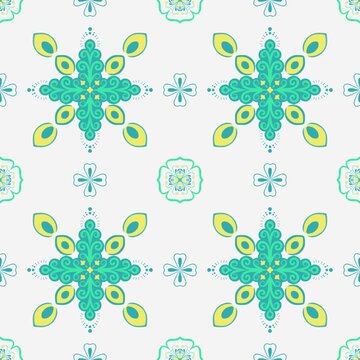 Seamless ornamental pattern featuring turquoise and lime botanical medallions with curling foliage, yellow leaf accents, small floral motifs and dotted details arranged on a light background.