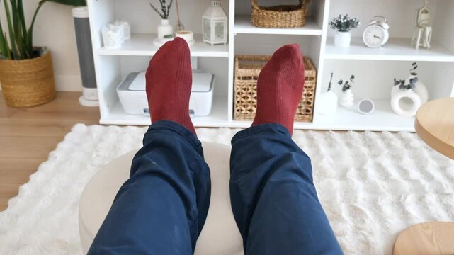 Person relaxing indoors with red socks in a cozy living space