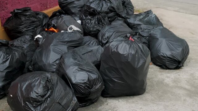 Large pile of black garbage bags illustrating household waste, excessive consumption, waste disposal, plastic pollution and the growing environmental impact of human activity.