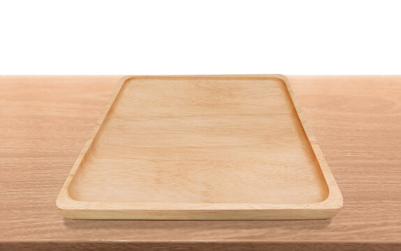 Empty rectangular wooden tray on wooden table surface, top view oblique angle.