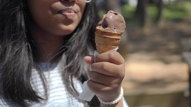 Child enjoys ice cream cone in park on a sunny day