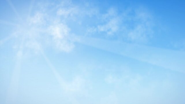 Bright summer sky with sun rays shining through light white clouds moving slowly in soft blue atmosphere view