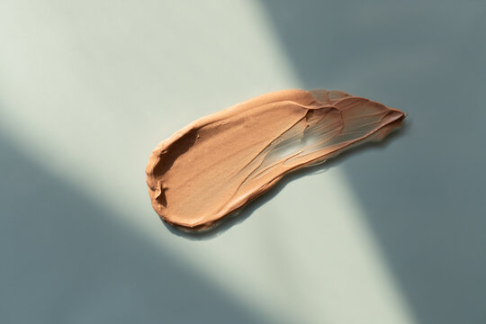 Beige liquid foundation smear, concealer texture smudge. Make up base drops, cream textured background. Closeup macro. Cosmetic tonal makeup moisturizer, bb cream swatch
