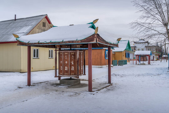 Ivolginsky Datsan courtyard in Buryatia, Russia, with wooden Buddhist buildings, temple architecture, and red prayer drums.
