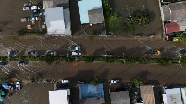 An elevated view of a flooded road with vehicles driving through the water.	
