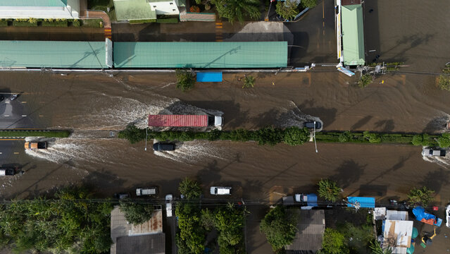 An elevated view of a flooded road with vehicles driving through the water.	