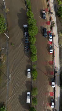 An elevated view of a flooded road with vehicles driving through the water.	
