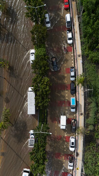 An elevated view of a flooded road with vehicles driving through the water.	