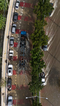 An elevated view of a flooded road with vehicles driving through the water.	
