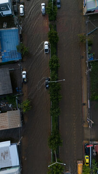 An elevated view of a flooded road with vehicles driving through the water.	