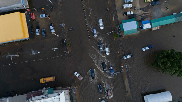 An elevated view of a flooded road with vehicles driving through the water.	