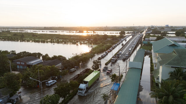 An elevated view of a flooded road with vehicles driving through the water.	