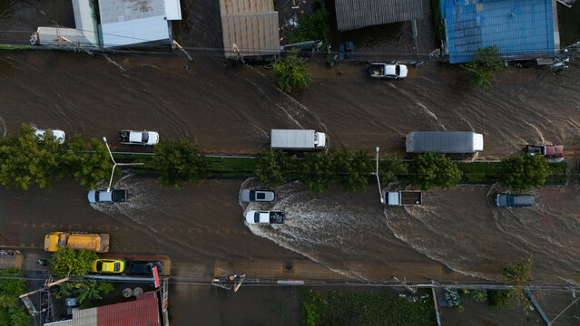 An elevated view of a flooded road with vehicles driving through the water.	