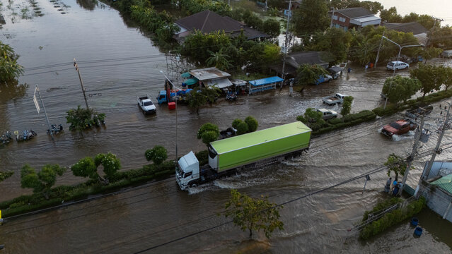 An elevated view of a flooded road with vehicles driving through the water.	