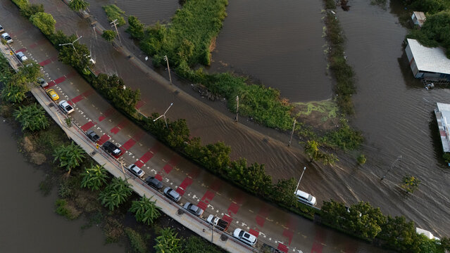 An elevated view of a flooded road with vehicles driving through the water.	
