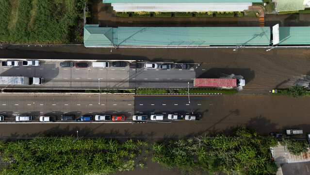 An elevated view of a flooded road with vehicles driving through the water.	