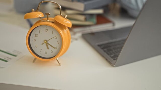 Woman rests head on stack of books with laptop and alarm clock on desk in building; fatigue study pressure.