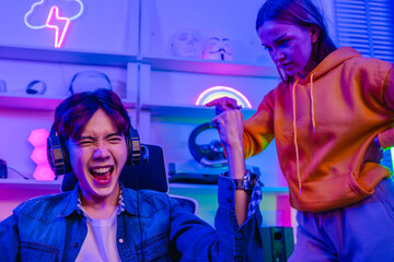 Upset girlfriend complaining to excited boyfriend gamer who laughs while playing video games © SpaceOak