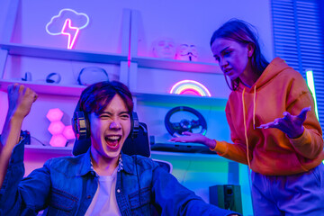 Upset girlfriend complaining to excited boyfriend gamer who laughs while playing video games © SpaceOak