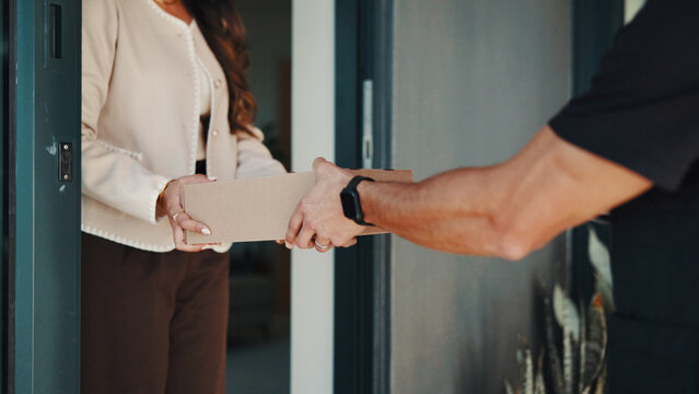 Hands, woman and delivery man at front door with box, ecommerce package and shipping service at home. Shopper, person and courier worker at house with parcel distribution, customer order and postage
