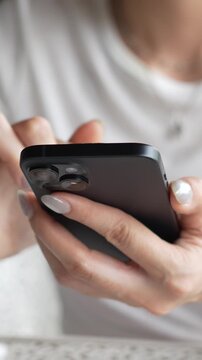 woman holds smart phone in her hands and scrolls through the news feed. Close up of hand uses mobile. point finger on screen, texting text message.