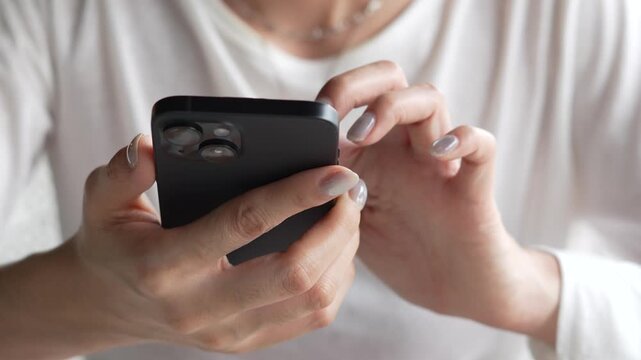 woman holds smart phone in her hands and scrolls through the news feed. Close up of hand uses mobile. point finger on screen, texting text message.