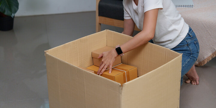 Cropped view of small business owner packing cardboard box for e-commerce delivery