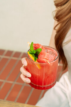 Summer party woman holding watermelon frozen cocktail in glass with