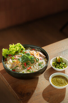 Vietnamese noodle soup with fresh herbs and vegetables in a bowl on