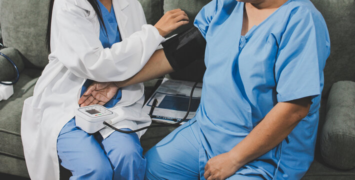 Doctor taking patient's blood pressure with a digital monitor, healthcare checkup, medical examination