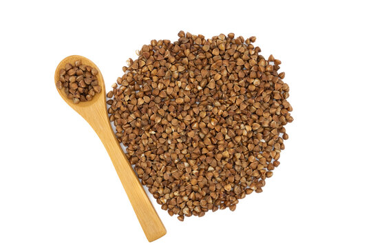 Pile of raw buckwheat grains with wooden spoon isolated on white. Natural healthy cereal, gluten-free food concept, minimalistic food composition.